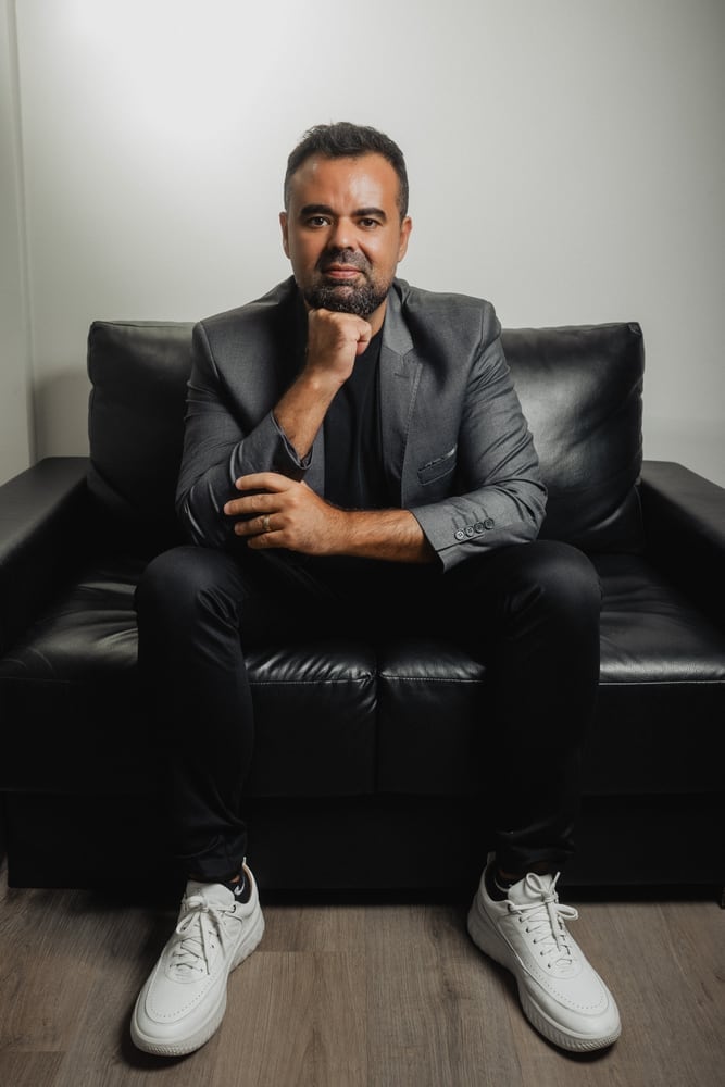 João Paulo Silva sentado, de blazer